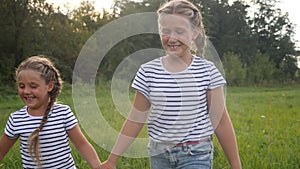 Kids walking in the park holding hands. children kid dreams happy childhood concept. two sisters are holding hands are