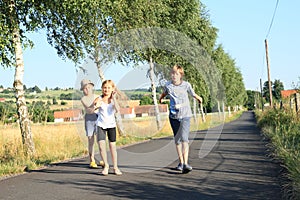 Kids walking on road with trees