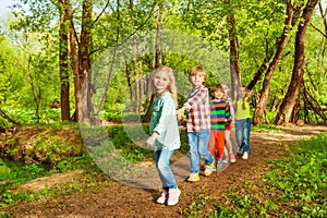 Kids walking in the summer forest holding hands