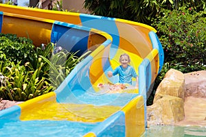 Kids on water slide in aqua park. Summer vacation