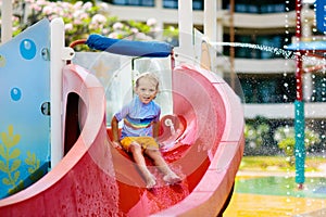 Kids on water slide in aqua park. Summer vacation