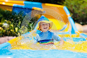 Kids on water slide in aqua park. Summer vacation