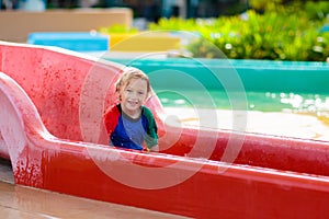 Kids on water slide in aqua park. Summer vacation