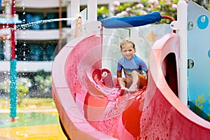 Kids on water slide in aqua park. Summer vacation