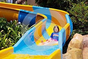 Kids on water slide in aqua park. Summer vacation