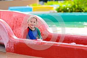 Kids on water slide in aqua park. Summer vacation