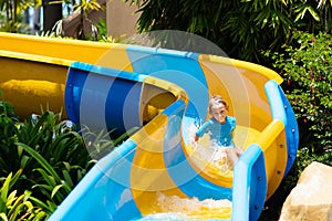 Kids on water slide in aqua park. Summer vacation