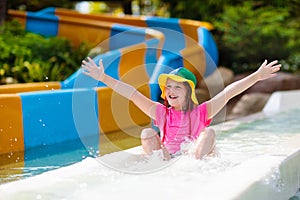 Kids on water slide in aqua park. Summer vacation