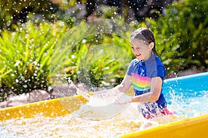 Kids on water slide in aqua park. Summer vacation