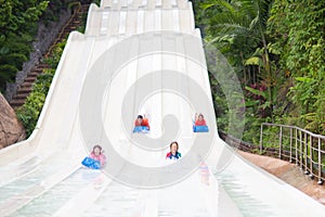 Kids on water slide. Family in aqua theme park