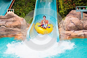 Kids on water slide. Family in aqua theme park