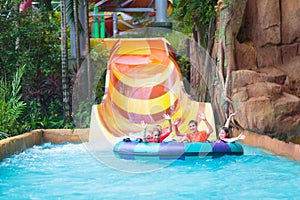 Kids on water slide. Family in aqua theme park