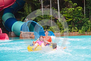 Kids on water slide. Family in aqua theme park