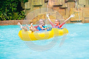Kids on water slide. Family in aqua theme park