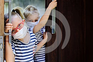 Kids wearing face masks peeking out the door