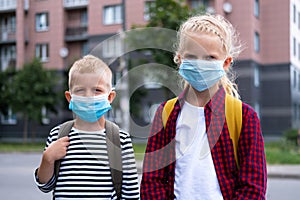 Kids wearing mask and backpacks protect and safety from coronavirus for back to school. Brother and sister going school