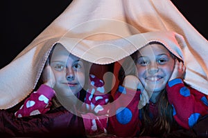 Kids wearing red jammies in bed on black background