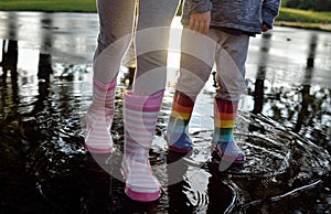 Kids wearing striped wellingtons in the puddle