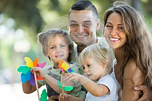 Kids with windmills on parentâ€™s arms