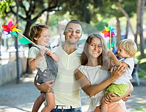 Kids with windmills on parentâ€™s arms