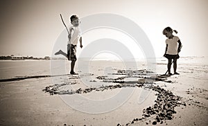 Kids writing in sand