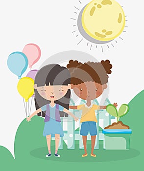 Kids zone, happy little girls with balloons potted plant fence sun grass outdoors