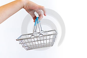 Kidâ€™s hand carries Small shopping basket on white background. It is a symbol of online shopping