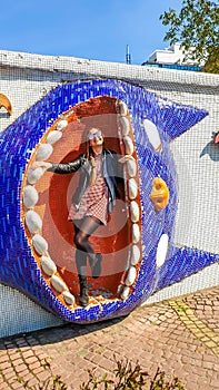 Kiev - A girl standing inside the mouth of a mosaic cat