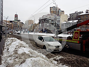 Kiev, March 6, 2018, Ukraine. Traffic police officers on street to pick up intruder`s car on tow truck. Loading tow truck car of