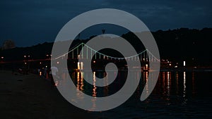 Kiev pedastrian bridge illumination on Dnipro river reflection Ukraine travel