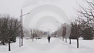 KIEV, UKRAINE - JANUARY 2, 2021: Man walking park through heavy snow beautiful winter day