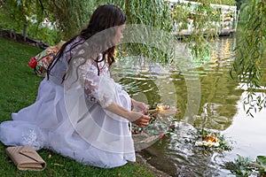 Kiev, Ukraine - July 06, 2018: Girl launches a wreath performing a Slavic ritual of fortune telling on the pagan holiday of Ivan K