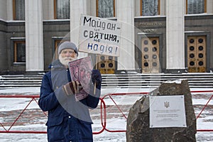 Kiev, Ukraine - March 04, 2018: An elderly man in a solitary picket near the High Rada with an icon and a poster