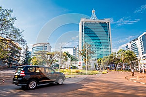 Kigali, Rwanda - September 21, 2018: A car passes the city centre roudabout, with Pension Plaza and surrounding buildings in