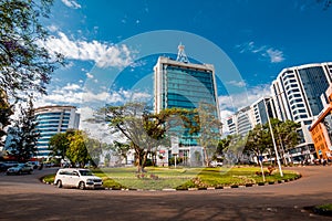 Kigali, Rwanda - September 21, 2018: A car passes the city centre roudabout, with Pension Plaza and surrounding buildings in