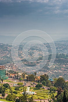 Kigali, Rwanda - September 21, 2018: A high angle view of the fountain roundabout near the city centre with rows of hills fading