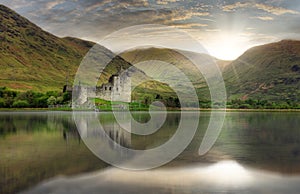 Kilchurn Castle with reflection in water at dramatic sunset, Nice Scotland landscape