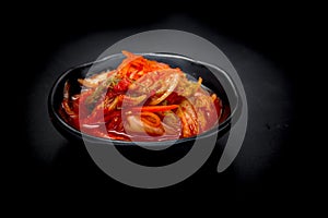 Kimchi on black dish on black background. Kimchi is the national dish of Koreans That is more popular.
