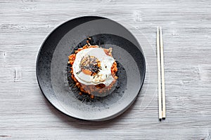 Kimchi bokkeum bap on black plate and chopsticks