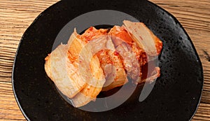 Kimchi Closeup, Kimchee Texture on Black Plate, Red Spicy Kim Chi, Hot Fermented Napa Cabbage