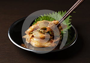 Kimchi set against a dark wooden background
