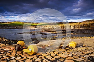 Kimmeridge sunshine illuminating golden rocks on the shoreline