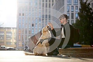 Kind blind man play with golden retriever