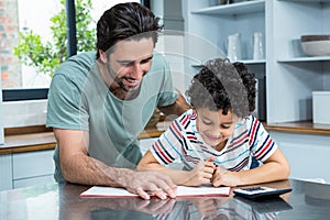 Kind father helping his son doing homework