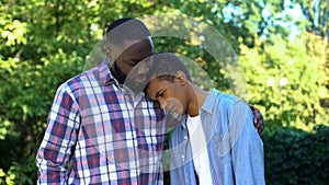 Kind father hugging teenage son admitting guilt, child upbringing, parenting