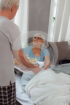 Kind man handing tasty morning food to his spouse