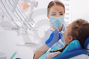 Kind orthodontist holding a dental mirror while working photo