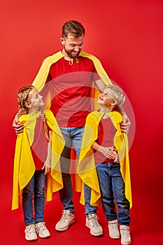 Kind responsible father with children pretend to be superhero