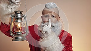 Kind smiling Santa Claus holds lamp, Christmas spirit, happy New Year tradition