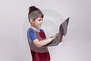 Kindergarten child holding a laptop and learning